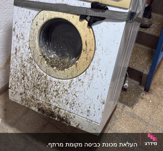 מכונת כביסה מלוכלכת מועברת במדרגות